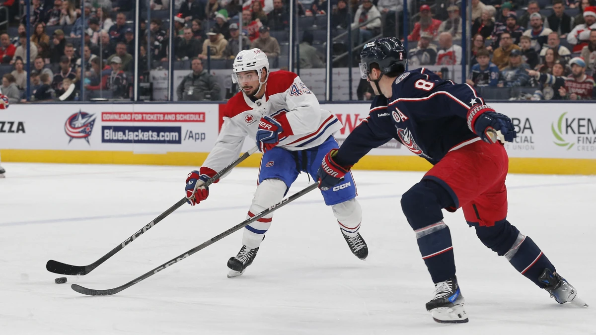Montreal Canadiens defenseman Alexandre Carrier (45) passes the puck as Columbus Blue Jackets defenseman Zach Werenski (8) defends during the first period at Nationwide Arena.