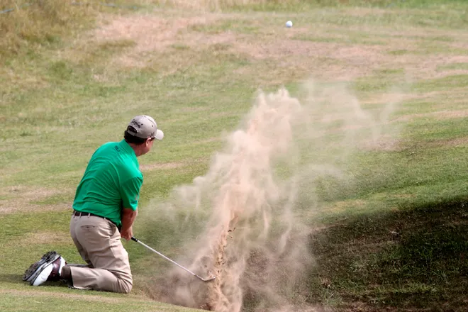 Tom Watson tries to escape from a precarious lie in a pot bunker during the second round of the 2013 Senior Open Championship played at Royal Birkdale Golf Club in Southport, England.