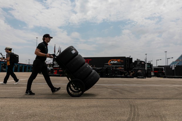 A crew member for a racing team takes a set of tires from the garages to pit row before qualifying for the NASCAR eero 400 at Chicagoland Speedway on Saturday, July 4, 2026, in Joliet. (Vincent D. Johnson/For the Daily Southtown)