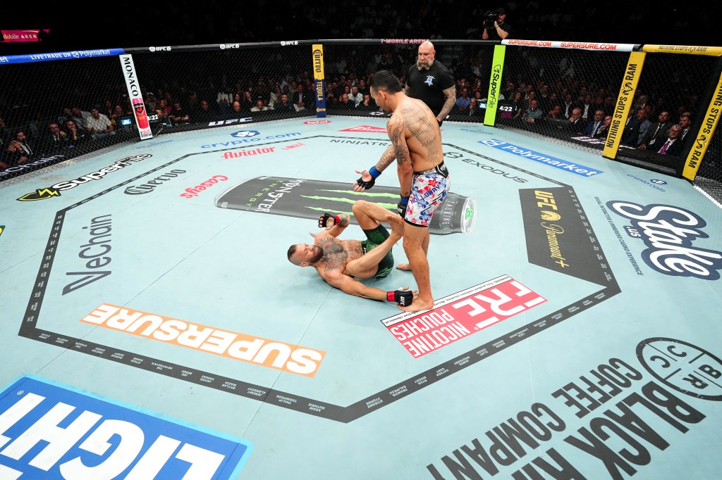 Max Holloway gestures at Conor McGregor during UFC 329. 