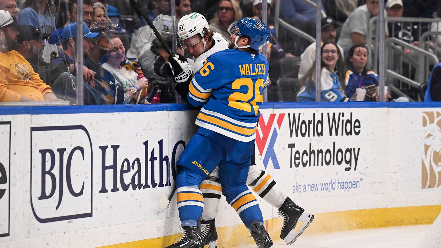 Apr 14, 2026; St. Louis, Missouri, USA;  St. Louis Blues left wing Nathan Walker (26) checks Pittsburgh Penguins defenseman Jake Livanavage (57) during the second period at Enterprise Center. Mandatory Credit: Connor Hamilton-Imagn Images