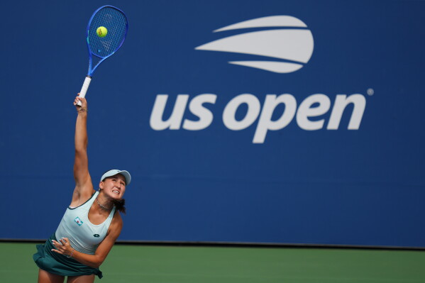 Kamilla Rakhimova, of Uzbekistan, serves the ball to Barbora Krejcikova, of the Czech Republic, during the first round of the U.S. Open tennis championships Sunday, Aug. 30, 2026, in New York. (AP Photo/Kirsty Wigglesworth)