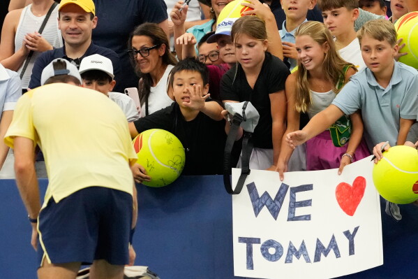 Spectators ask for autographs from Tommy Paul, of the United States, after he defeated Coleman Wong, of Hong Kong, during the first round of the U.S. Open tennis championships Sunday, Aug. 30, 2026, in New York. (AP Photo/Yuki Iwamura)