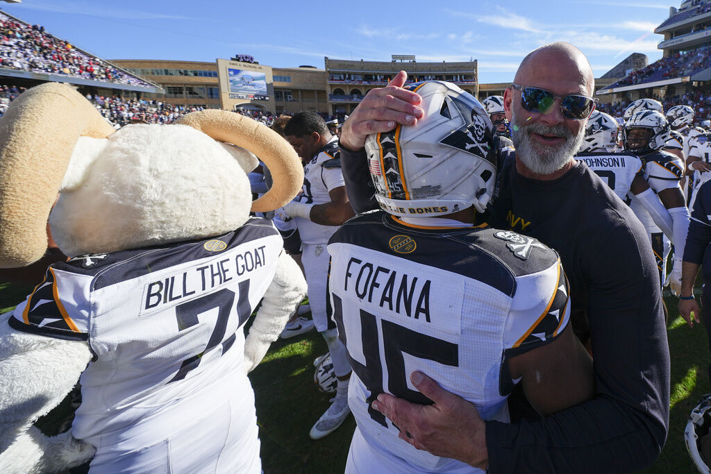 Navy head coach Brian Newberry, right, hugs fullback Daba Fofana following the Armed Forces Bowl NCAA college football game, Friday, Dec. 27, 2024, in Fort Worth, Texas. Navy won 21-20. (AP Photo/Julio Cortez)
