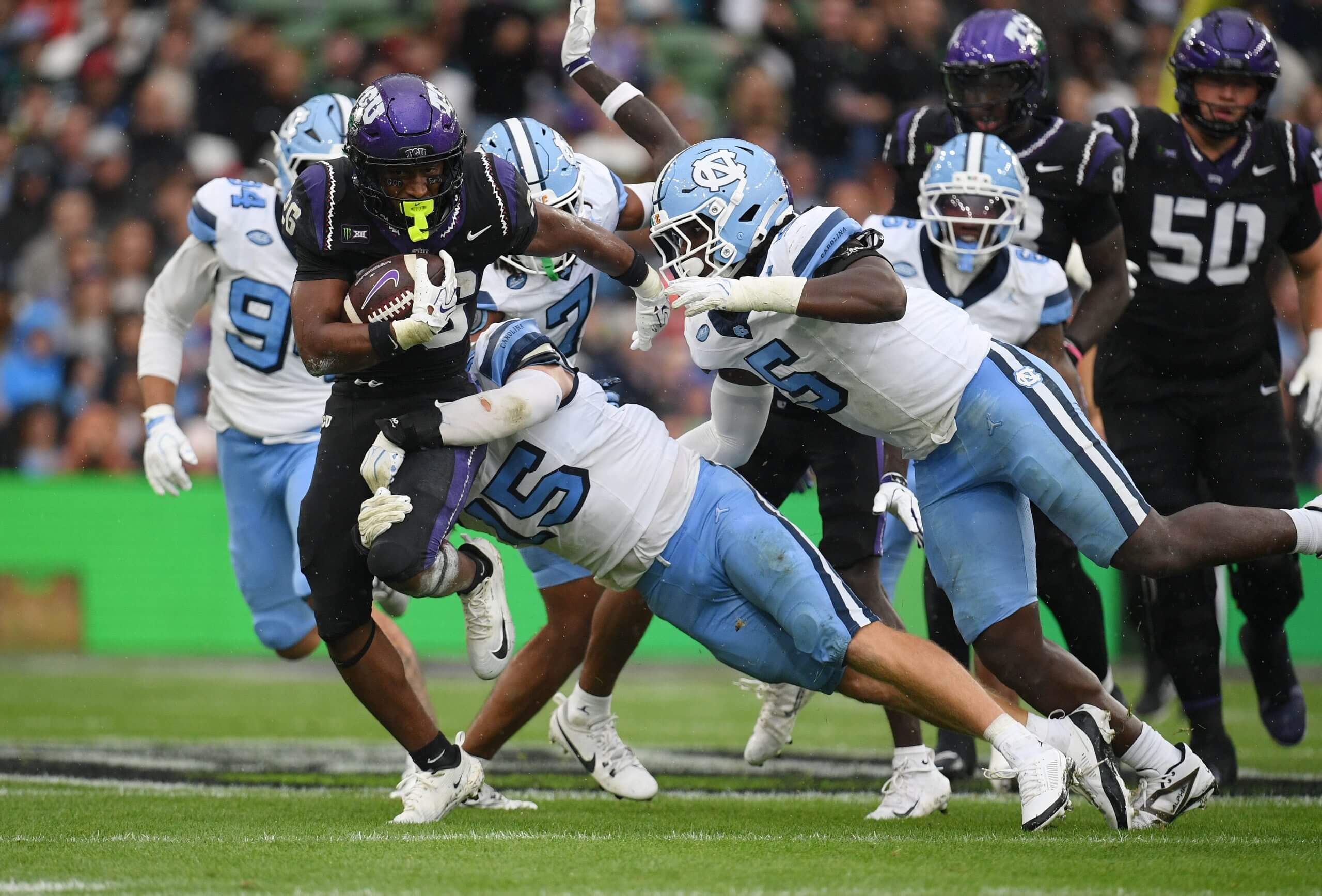 Three North Carolina defenders tackle TCU's Jeremy Payne