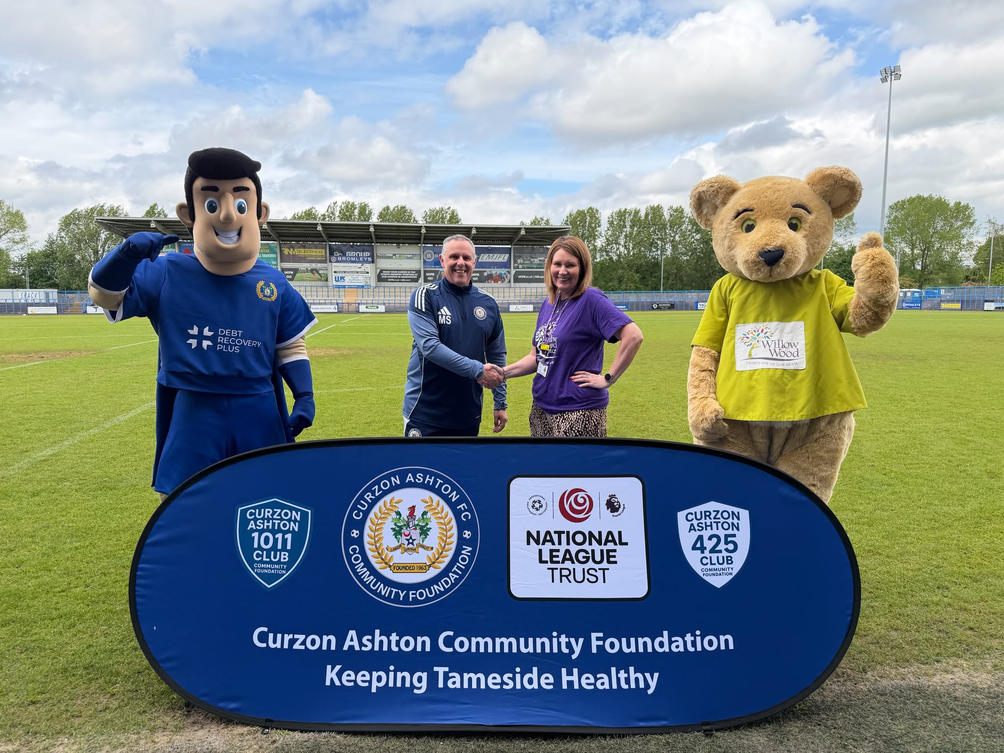 Mike Smith from Curzon Ashton and Joanne Lees from Willow Wood Hospice with the football club and Hospice's mascots
