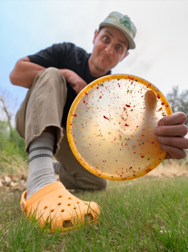 Jesse Stedman, founder and CEO of Trash Panda Disc Golf, shows off one of the discs made in collaboration with Crocs footwear company. The two Colorado-based companies have an ongoing partnership that allows Trash Panda to incorporate "shreds" from old Crocs shoes into its discs, which are made using 100% recycled plastic. (Provided by Trash Panda Disc Golf)