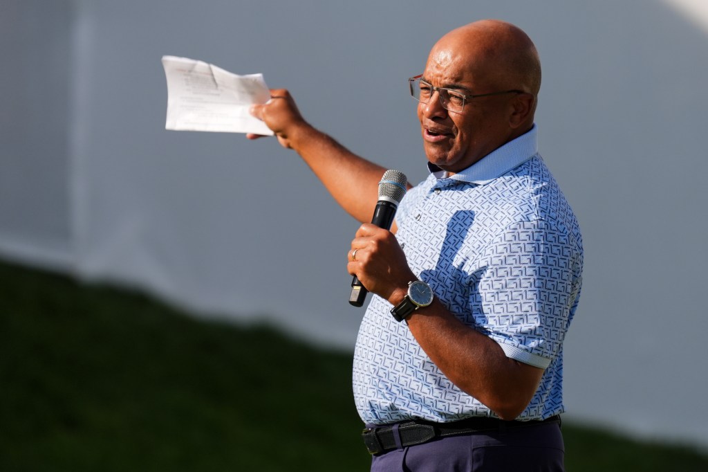 Broadcaster Mike Tirico addresses spectators after the final round of the Rocket Classic golf tournament.