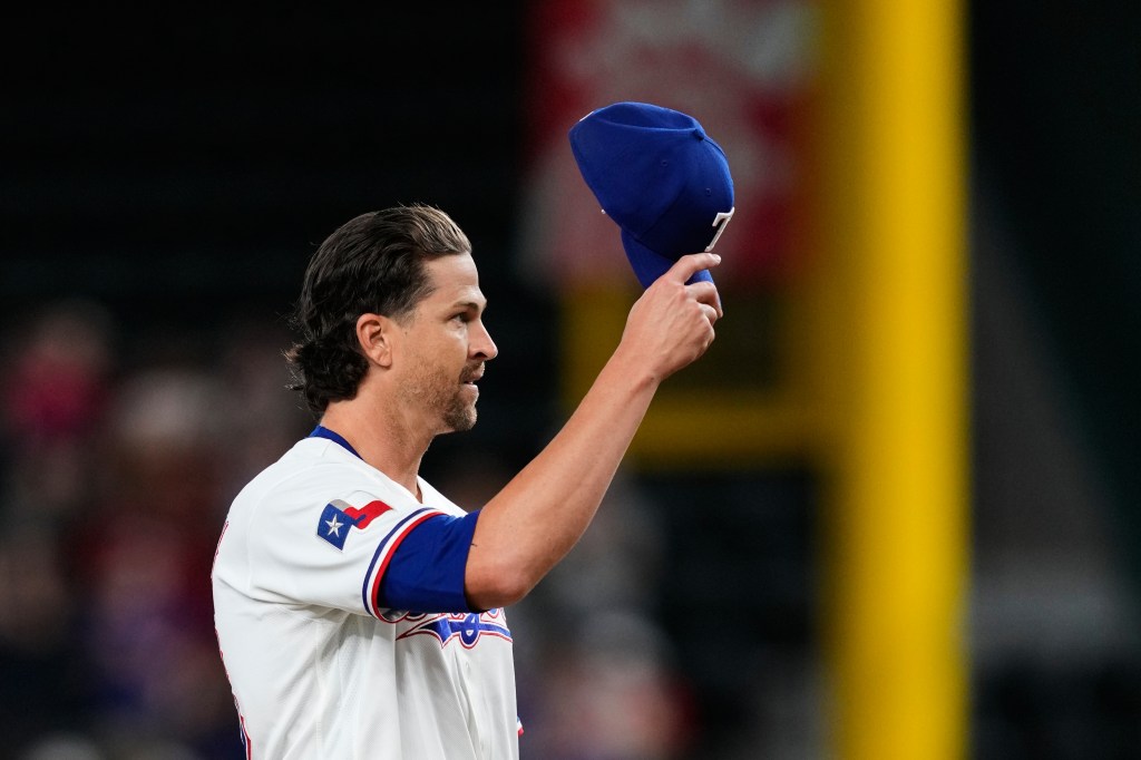 Texas Rangers pitcher Jacob deGrom acknowledges cheers from fans after his 2,000th career strikeout.