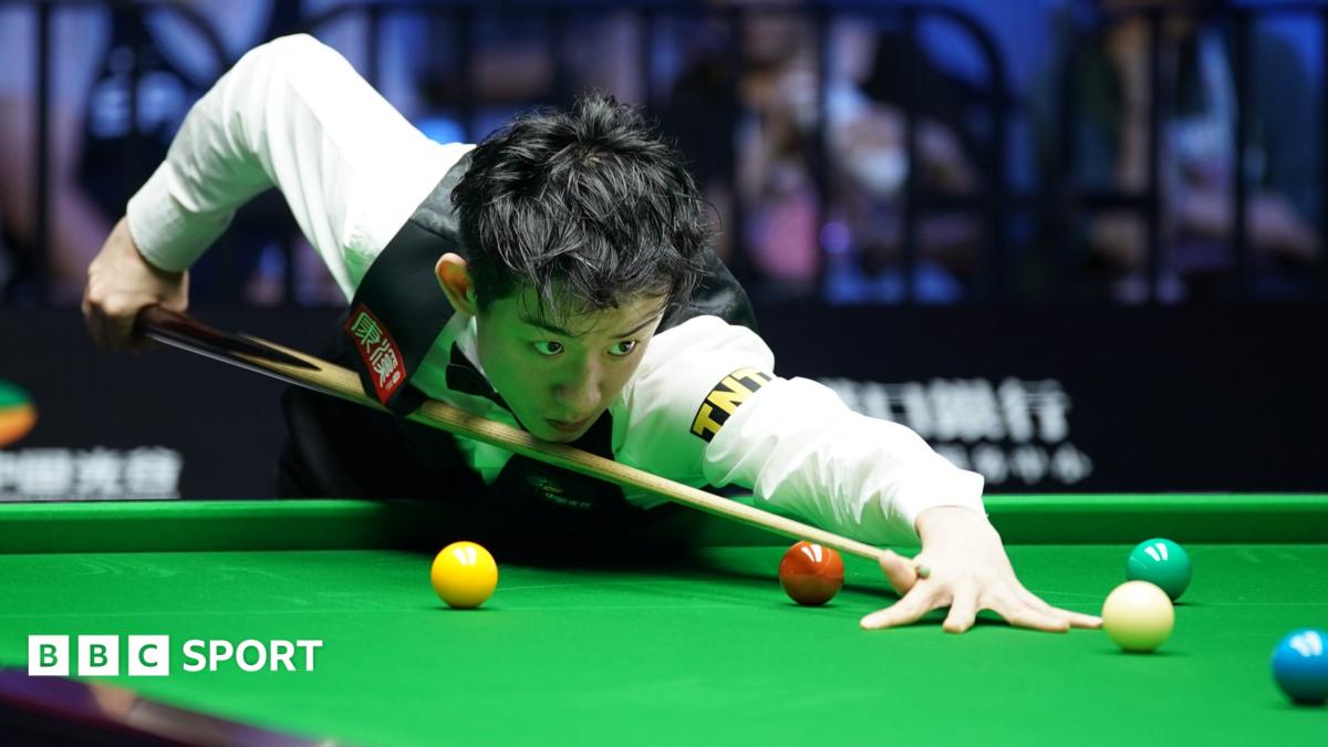 Snooker player Wu Yize takes aim as he plays a shot