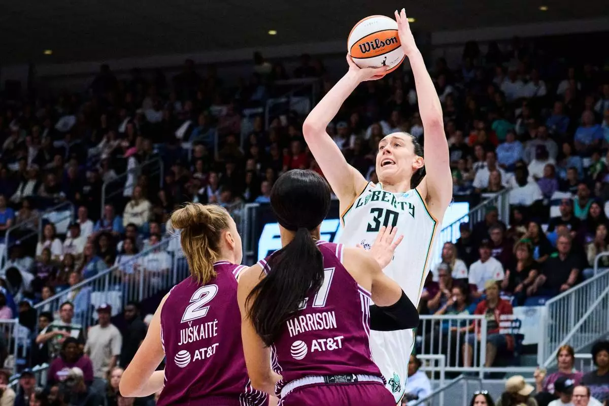 New York Liberty's Breanna Stewart (30) looks to shoot over Toronto Tempo's Laura Juskaite (2) and Isabelle Harrison, front right, during the first half of a WNBA basketball game in Toronto, Sunday, Sept. 20, 2026. (Sammy Kogan/The Canadian Press via AP)