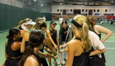 The Grinnell women's tennis team does a cheer in the Grinnell Fieldhouse before beginning singles matches against Luther College on Saturday, Sept. 19.
