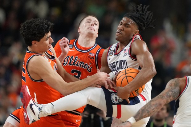 UConn's Silas Demary Jr., right, battle for the ball with Illinois' Andrej Stojakovic, left, and Ben Humrichous during the second half of an NCAA college basketball tournament semifinal game at the Final Four, Saturday, April 4, 2026, in Indianapolis. (AP Photo/Michael Conroy)