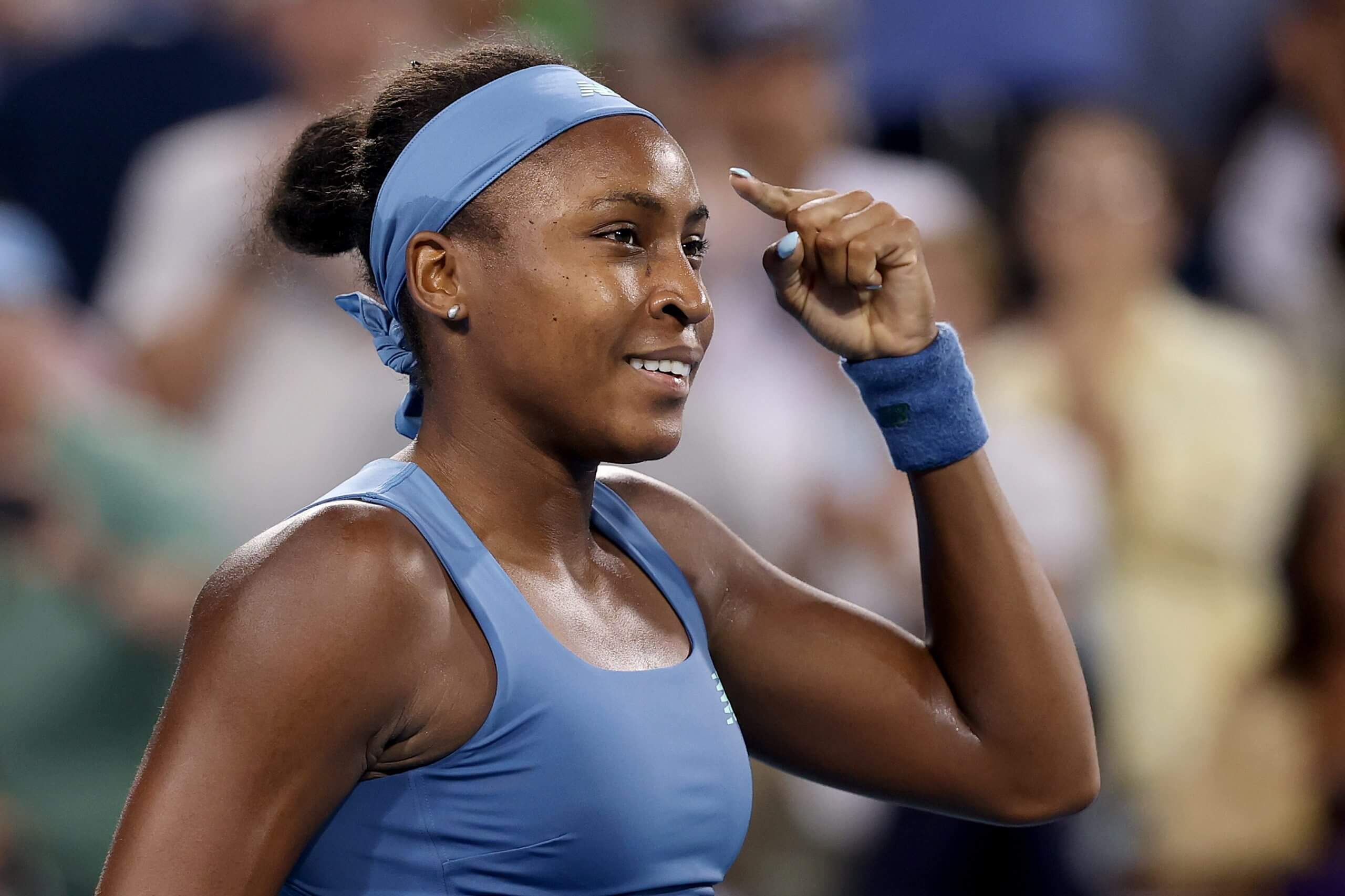 Coco Gauff points to her head.