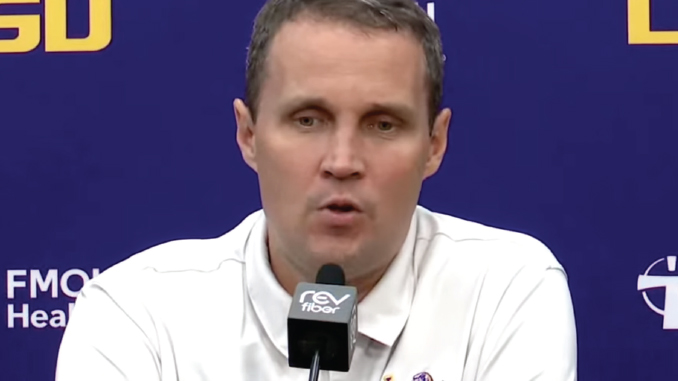 WillWade_Presser092326_Screenshot Man in a white polo shirt speaks into a microphone at a press conference with a blue backdrop and logos behind him.