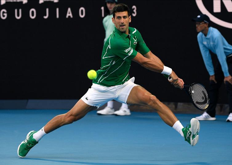 Novak Djokovic making a backhand return.
