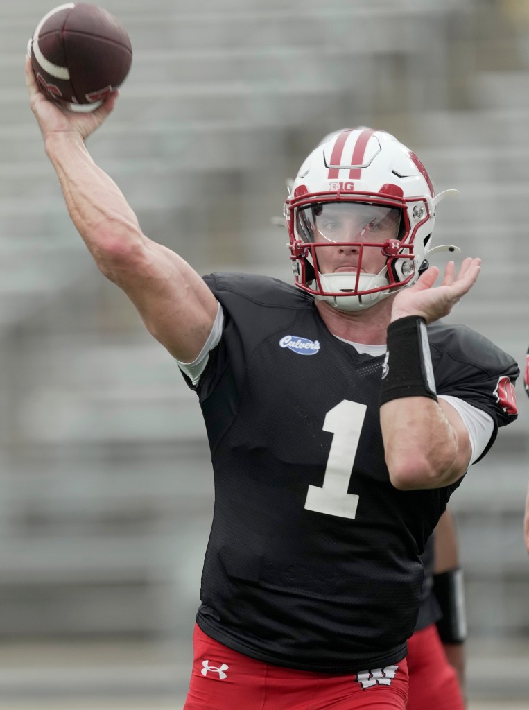 Quarterback Colton Joseph in a Wisconsin Badgers uniform throwing a football.