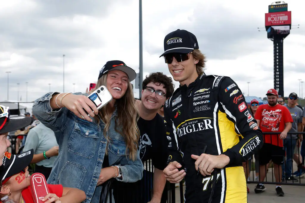 Carson Hocevar, right, interacts with fans before a NASCAR Cup Series auto race in Kansas City, ...