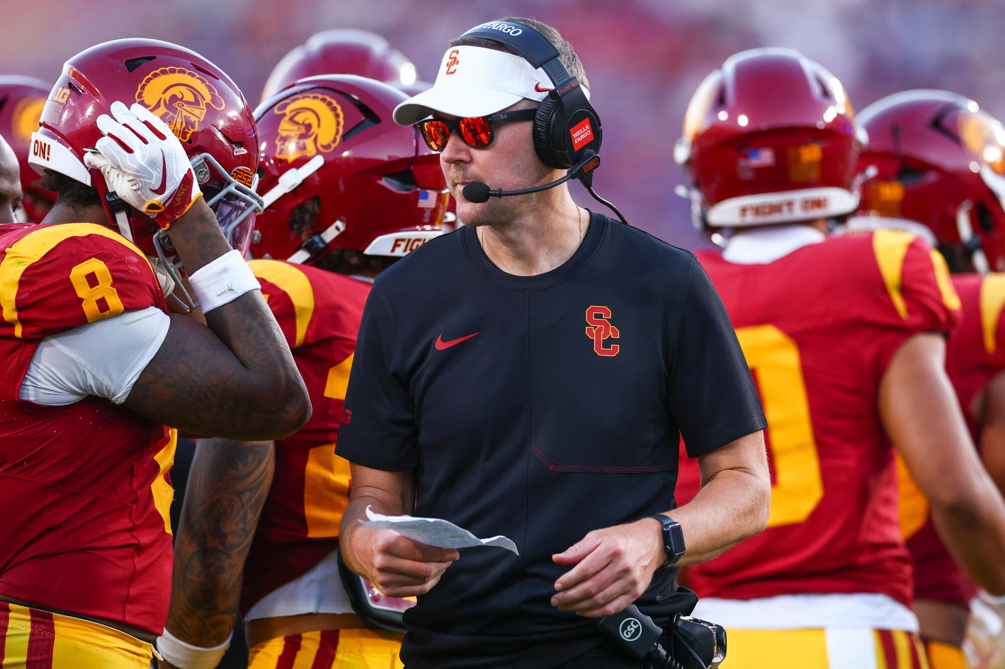 USC coach Lincoln Riley walks back to the sideline after speaking with his players during a timeout.