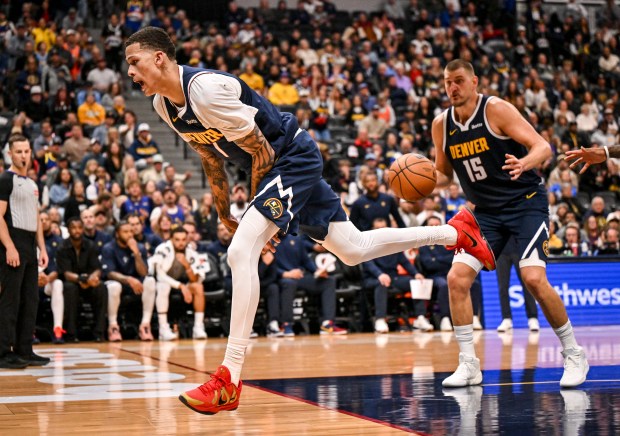 Trevon Brazile (7) of the Denver Nuggets saves a loose ball as Nikola Jokic (15) awaits the delivery during the overtime period of the Nuggets' 141-135 win over the New Orleans Pelicans at Ball Arena in Denver, Colorado on Saturday, October 24, 2026. (Photo by AAron Ontiveroz/The Denver Post)