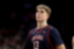 Arizona center Motiejus Krivas looks up toward the scoreboard in a navy No. 13 Wildcats uniform against a dark arena background.