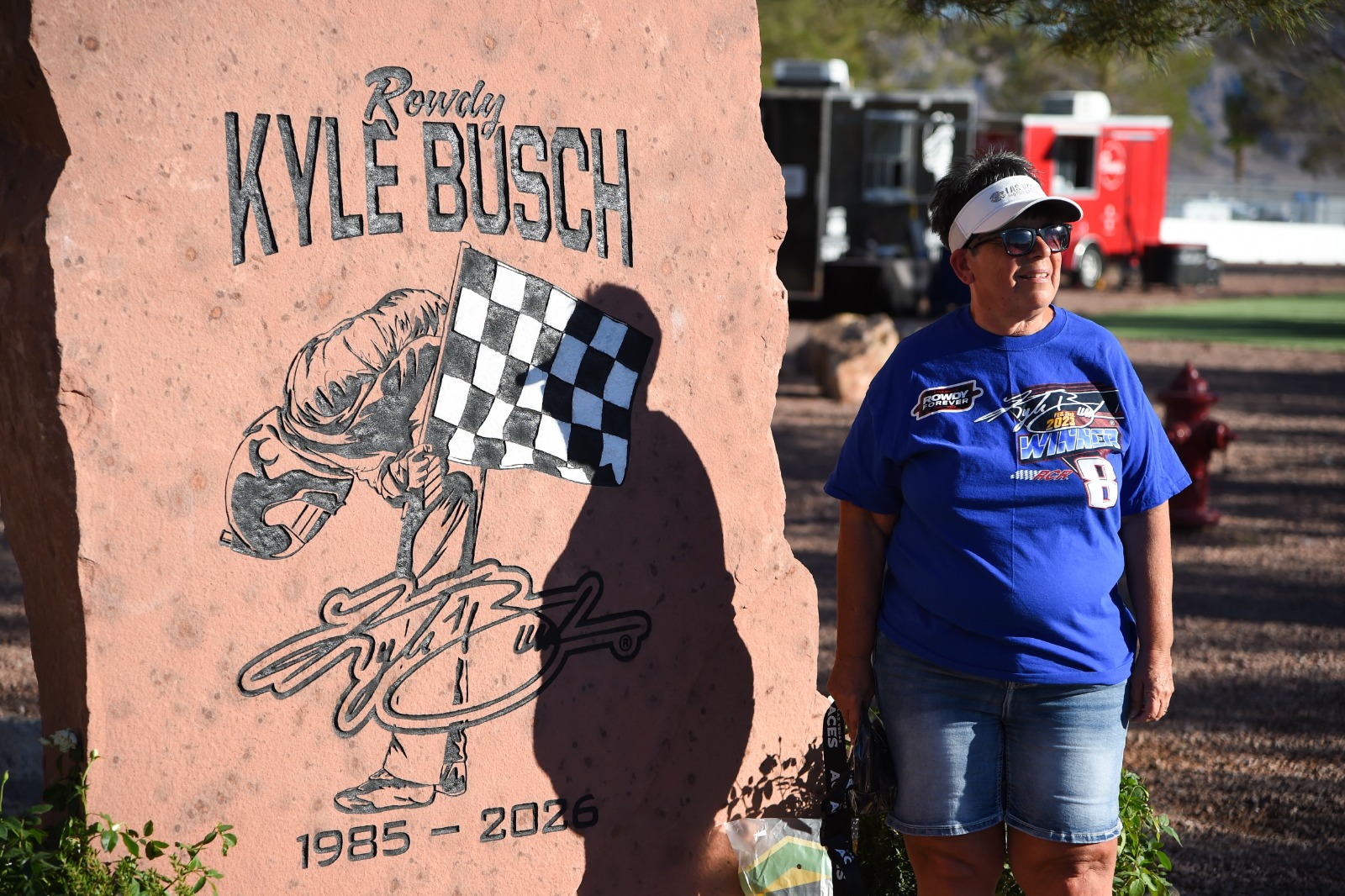  A Kyle Busch fan poses for a photo in front of he rock memorial