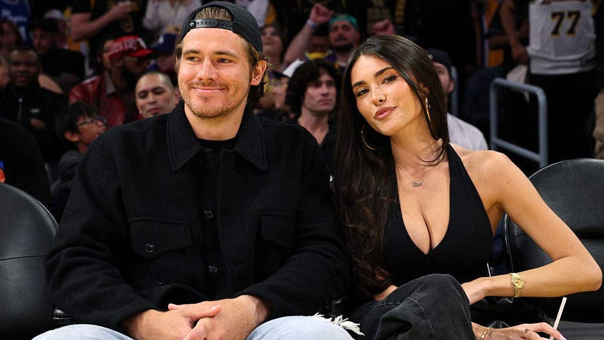 Justin Herbert and Madison Beer seated at a basketball game between the Lakers and Timberwolves.